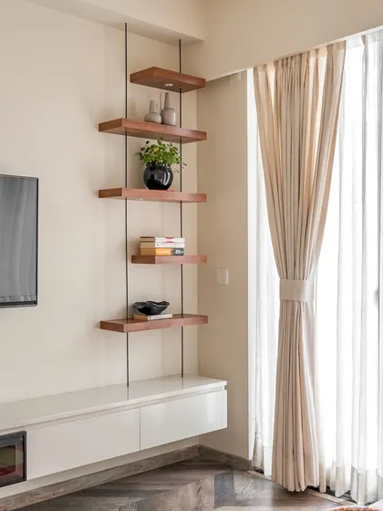 Another view of the minimalist TV unit and hanging corner shelves. This custom solution keeps the floor clear, making the room feel more spacious and open.