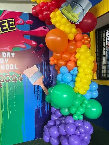 A close-up of the balloon art, showing how different colors and sizes of balloons are combined to create the effect of spilling paint, complete with a paintbrush prop.