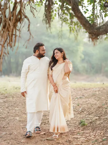 A natural, walking shot of the same couple under a large tree on the heritage grounds. This shows the blend of architecture and nature that many heritage sites offer.