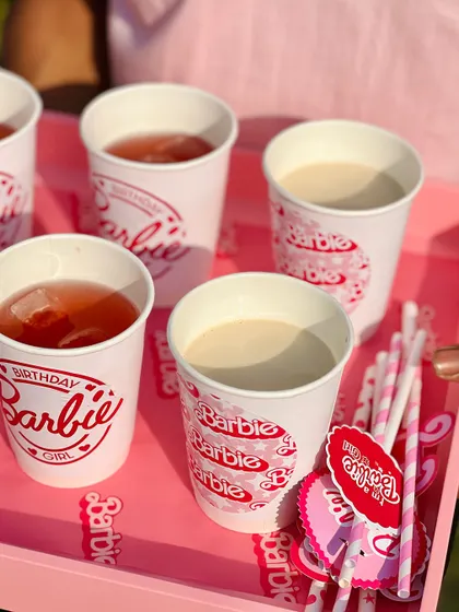 A tray of themed drinks, including pink lemonade and milkshakes, ready to be served to the party guests.