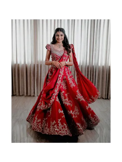 A full-length shot of Ashwini, her red lehenga swirling around her. The entire look is a perfect blend of tradition and modern elegance.