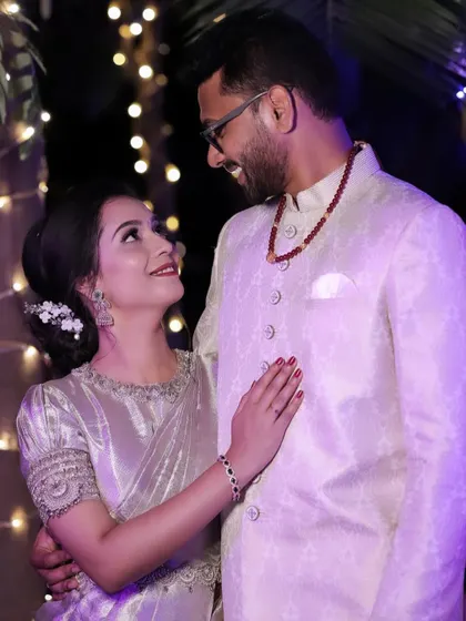 A romantic shot of the couple. The bride's soft, luminous makeup looks beautiful next to the groom's classic white sherwani.