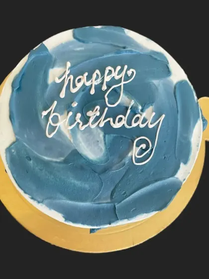 A minimalist cake with abstract blue buttercream strokes. This modern art-inspired design is perfect for someone with a contemporary and artistic style.