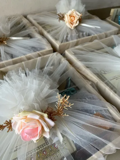 A closer look at the beautifully wrapped Ramadan gift trays, adorned with artificial roses and delicate tulle.