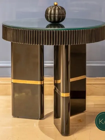 This modern side table features a fluted base with a high-gloss black finish and gold accents, topped with glass. It's a perfect example of our ability to create small but impactful pieces that exude luxury.
