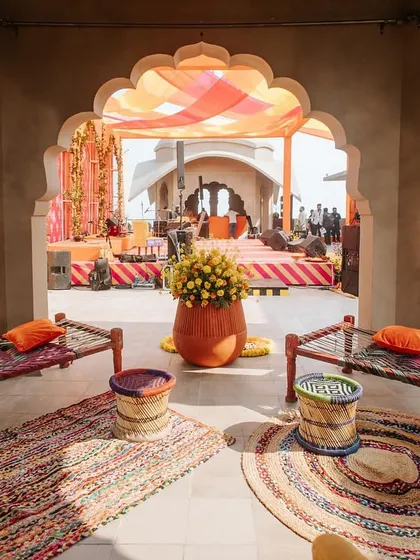 A cozy seating nook with traditional 'charpai' beds and colorful woven stools ('moodas'). This setup for the 'Jaipur Wali Haldi' was designed to evoke a sense of nostalgia and rustic charm.