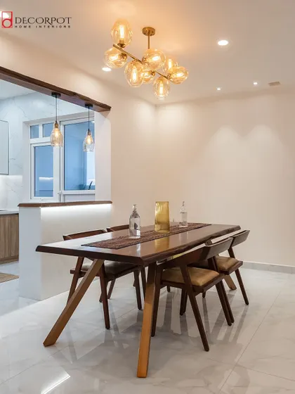 This dining area combines modern and rustic elements with a solid wood dining table and a stunning glass chandelier. The open layout connects the dining space to the kitchen, making it ideal for entertaining.