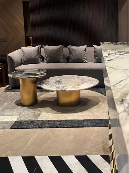 The living space in this Juhu apartment features a bold black-and-white striped marble floor. I balanced this strong element with soft grey upholstery and metallic accents for a sophisticated, modern look.