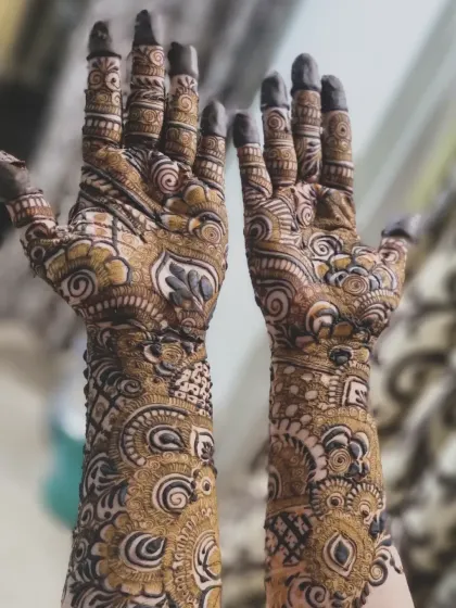 A closer look at an intricate design, showcasing the combination of swirls, paisleys, and shaded floral elements. The fingertips are fully covered, which gives a very traditional feel.