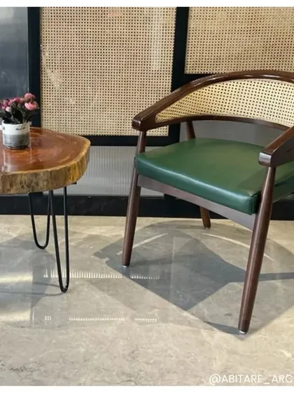 A close-up of a furniture pairing in one of our office projects. The natural-edge wood side table contrasts beautifully with the classic caned armchair, demonstrating our focus on selecting unique pieces that add character and texture.