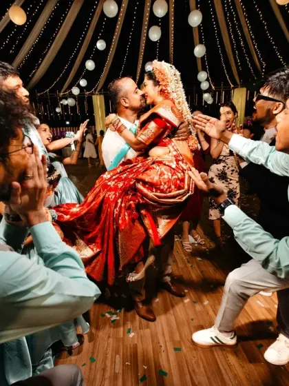 A wild and joyous moment on the dance floor, with the couple lifted up by their friends for a celebratory kiss.