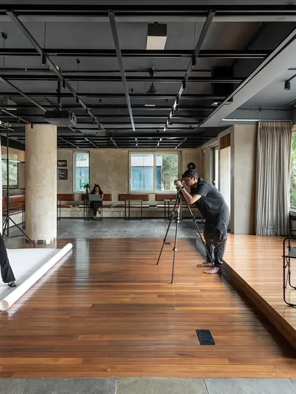 Demonstrating its functional flexibility, the central multi-purpose zone is shown here converted into a professional photography studio. The adaptable lighting grid and expansive wooden floor provide a neutral, functional backdrop for creative productions.