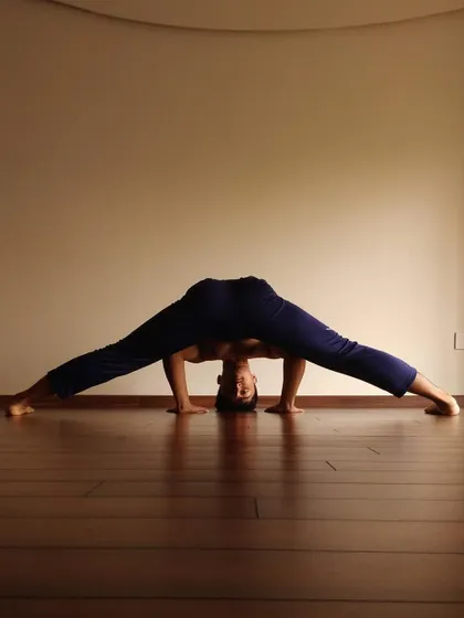 A deep forward bend in Prasarita Padottanasana, working to open the hamstrings and release the spine.
