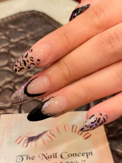 A bold and glamorous design on long stiletto nails. This set combines a black and glitter French tip with a fierce leopard print accent nail.