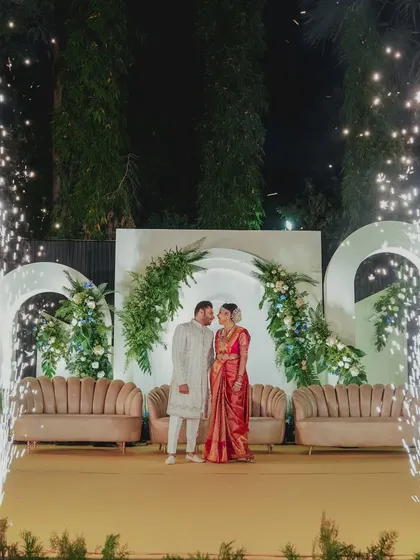 The couple surrounded by celebratory fireworks on their elegant reception stage, a perfect blend of modern design and festive grandeur.