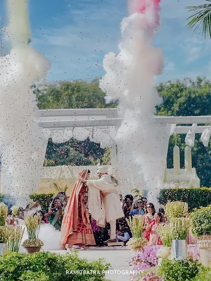 The grand Varmala ceremony with colorful smoke bombs, creating a painterly and dramatic effect.