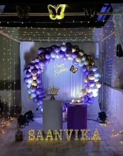 Our butterfly theme creates a magical and whimsical atmosphere. This beautiful terrace canopy setup for Saanvika's birthday features purple and gold balloons, fairy lights, and delicate butterfly accents.
