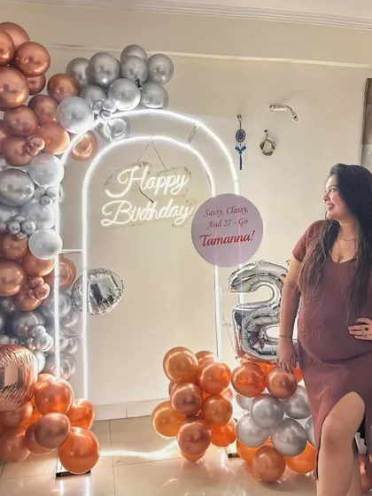 "Sassy, Classy, and 27!" A beautiful rose gold and silver theme for a 27th birthday, featuring a lit arch, custom sign, and large foil numbers. The birthday girl looks radiant!