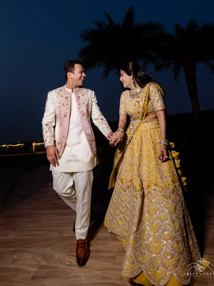 Styling for a sundowner engagement ceremony. The bride chose an unconventional chartreuse lehenga by Nidhi Tholia, and we styled the groom in a Jatin Malik couture open bandhgala with complementary ivory and pink tones.