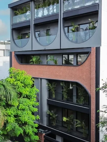 A real-world shot of the completed facade, blending design intent with on-site execution. The combination of brick, dark concrete, and geometric cutouts creates a unique identity for this urban residence.