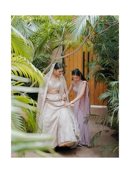 A behind-the-scenes shot of the bride getting ready with her sister, a moment of calm and support before the main event.