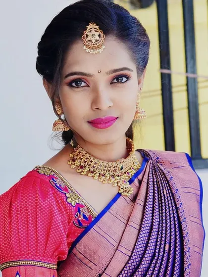 A beautiful close-up of a bride's engagement makeup. The look features sharp winged eyeliner, a bright pink lip, and a flawless base, all designed to make her features pop in photos.
