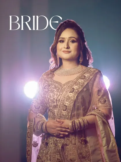 "Bride." A striking portrait of the bride, Shivani, against a backlit stage. Her confident pose and the dramatic lighting create a powerful and glamorous image.