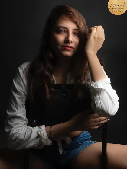 A strong, seated portrait for a modeling portfolio. The composition and lighting are designed to create a powerful and engaging image that stands out.