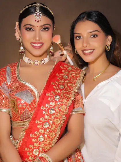 A behind-the-scenes moment with the artist and her model. This shows the final touches and the pride in creating a beautiful bridal look.