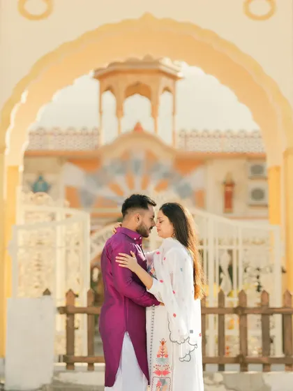 An intimate pre-wedding portrait framed by a beautiful archway at a Rishikesh ashram. The architecture adds a sense of grace and tradition to their modern love story.