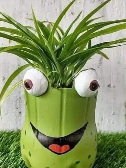 A front view of the happy frog planter, crafted from a green plastic bottle. This is a great example of how I use simple, recycled materials to create joyful garden decor.