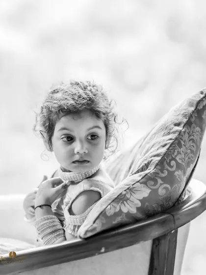 A candid black and white portrait of the little flower girl, looking thoughtful and sweet. A precious memory from the engagement ceremony.