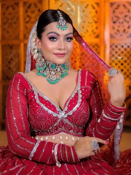 A playful shot of the bride adjusting her veil. Her direct gaze and smile create an engaging and lively portrait.