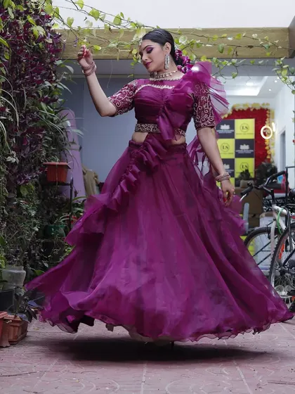 A fun, floating shot of the wine-colored ruffled lehenga, showing its light and airy organza fabric.
