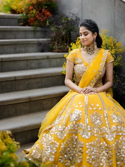 The full view of this stunning yellow lehenga and complementary makeup, ideal for a festive pre-wedding event.