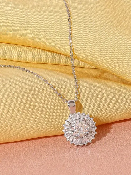 A classic shot of a silver and diamond halo pendant. The focus is entirely on the sparkle and design of the piece, making it look timeless and luxurious.