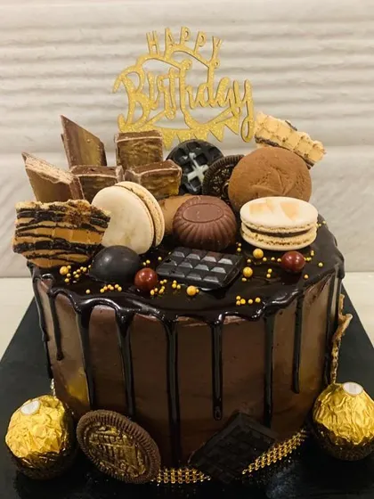 Love at first bite. This chocolate overload cake is a feast for the eyes and the palate, with a rich drip and a mountain of toppings.