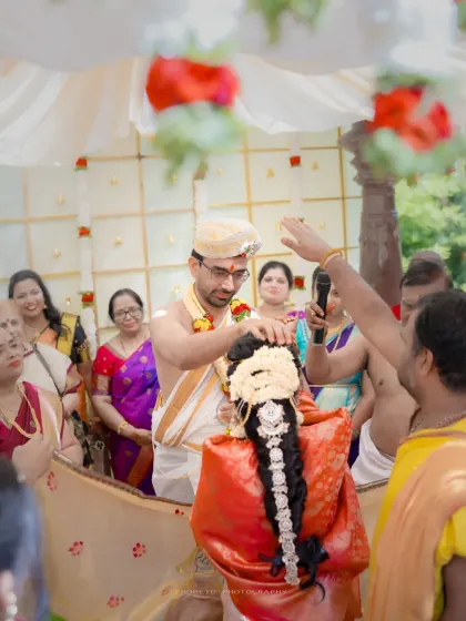 A key ritual from a South Indian wedding, captured from a perspective that includes the family and the priest.