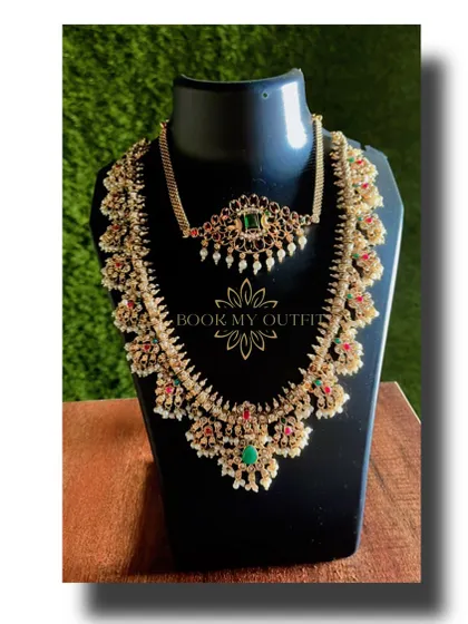 This layered bridal necklace set features a mix of pearls with red and green stones, giving you a colorful and royal look. The set includes a choker and a longer, more elaborate necklace to create a full bridal effect.
