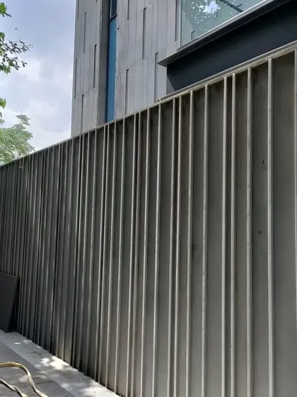 Another view of the fluted stone pattern on the boundary wall. This experiment with stone texture adds a layer of sophistication and visual interest to what is often a purely functional element.