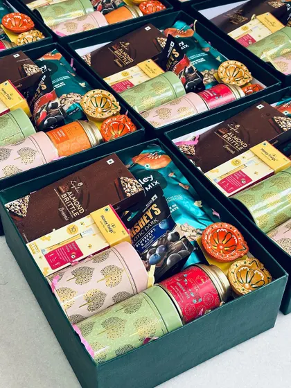 A side view of the open Diwali hampers, showing the depth and variety of items packed into each box.