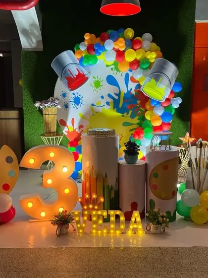 A full view of the art party stage, including a light-up marquee number "3" and personalized name.