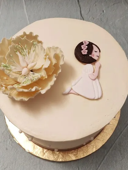 We craft a simple and spiritual cake for a Holy Communion. This design features a beautifully crafted sugar flower beside a praying girl figure, offering a moment of quiet reflection and grace for this important religious ceremony.