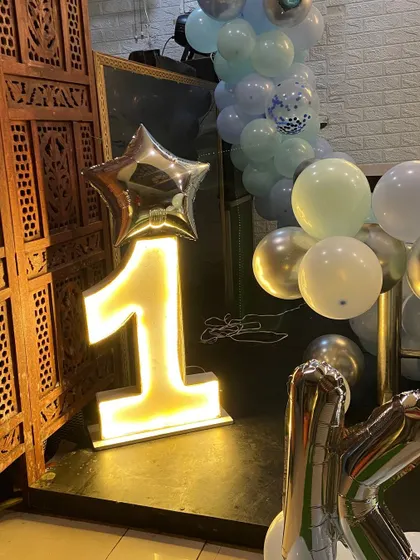 To make milestone birthdays stand out, I provide large, light-up marquee numbers. This glowing number '1' adds a professional and eye-catching element to a first birthday party, perfect for photos.