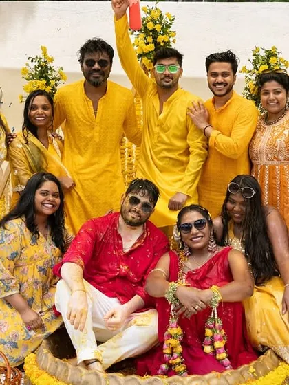 A fun group photo with the couple and their friends, all dressed in yellow for the vibrant Haldi party.
