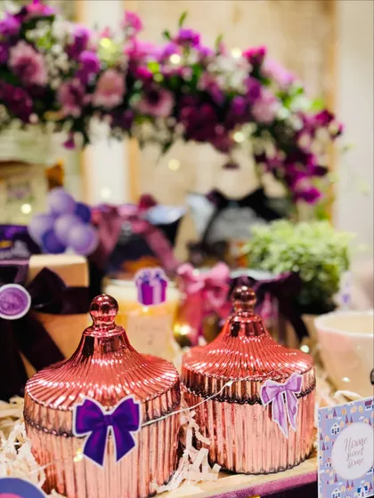 The rose-gold decorative jars with purple bow details are both beautiful and useful, making them a perfect addition to a new home.