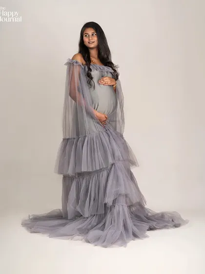 This pose captures the graceful flow of the grey gown, making the mother-to-be look like she's floating. My styling focuses on creating these ethereal, dream-like moments.