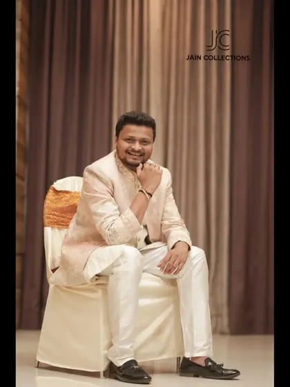 A happy client looking dapper in our pastel pink Jodhpuri suit. It's a great choice for a daytime event, offering a touch of color and elegance.