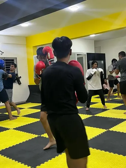 A wide shot of our boxing class in session. Fighters are paired up, drilling techniques and improving their skills together.