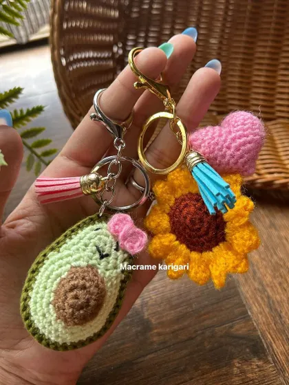 A trio of our cutest keychains: a smiling avocado, a sunflower with a heart, and a classic puff flower. These show the variety of custom designs we can create for you.